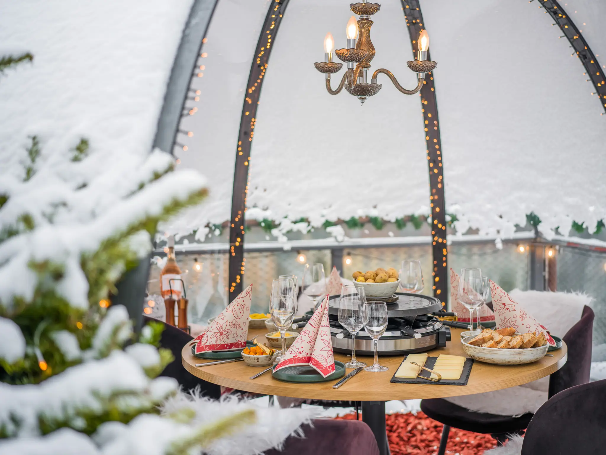 Festlich gedeckter Tisch im Iglu mit Kronleuchter und Lichterketten